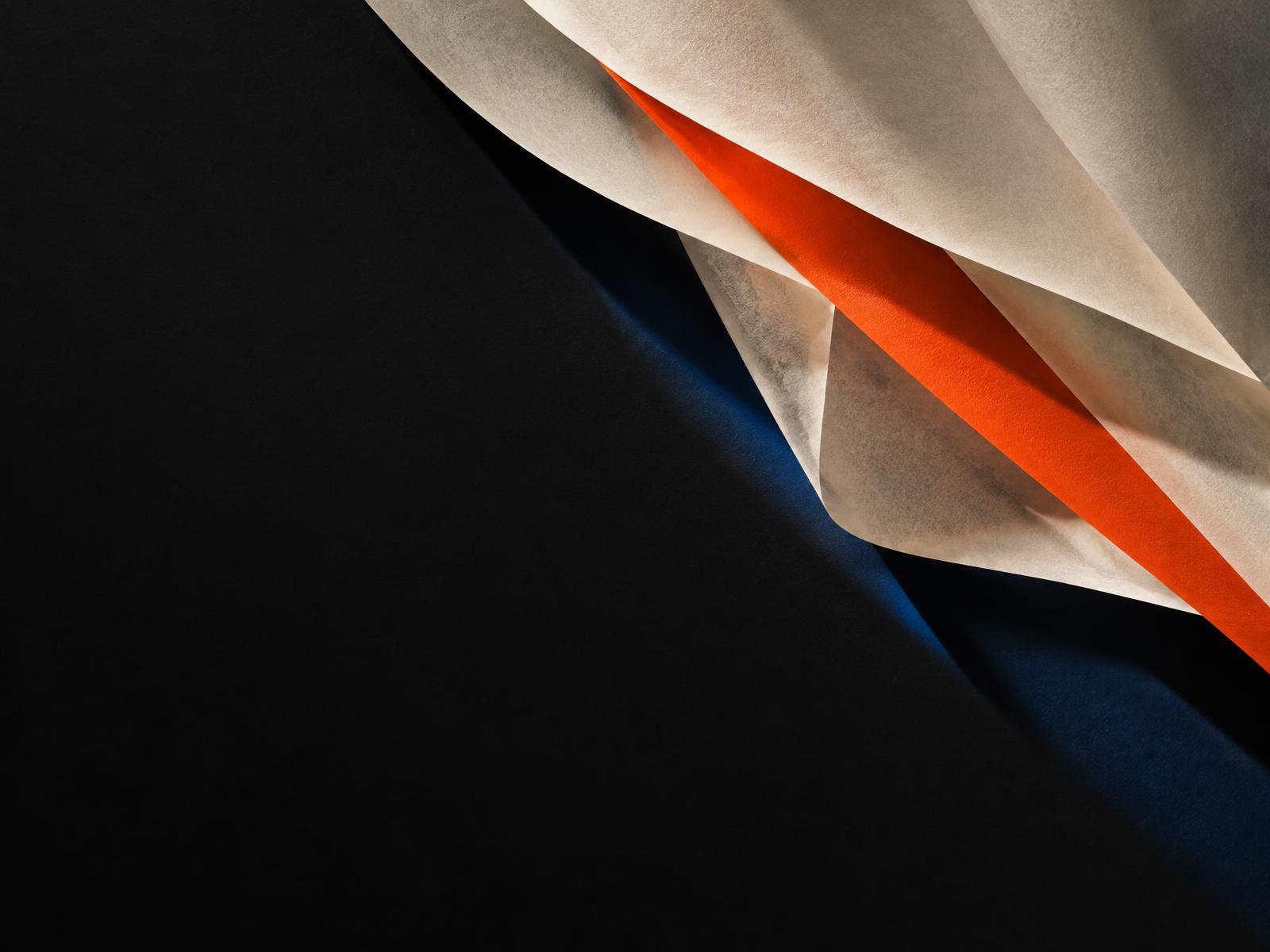 Abstract layered paper composition in ivory, vermilion and blue on black